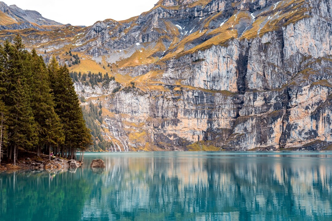 Snow-capped Swiss Alps overlooking a turquoise alpine lake at sunrise