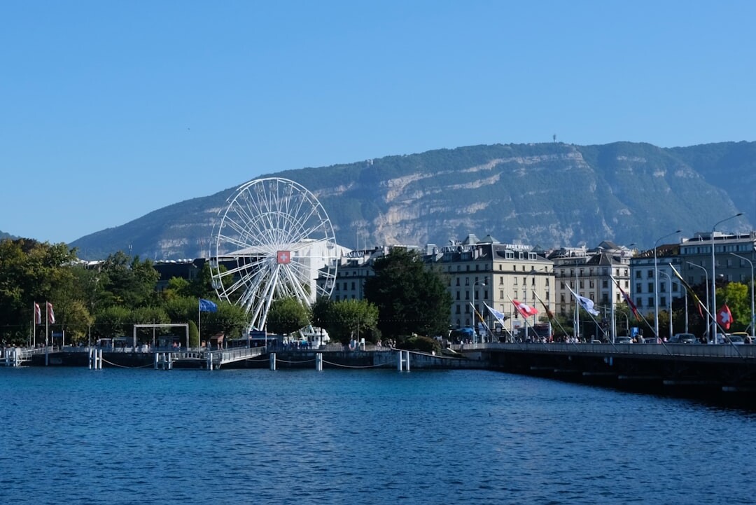 Lakeside promenade in Geneva with the Jet d'Eau fountain and mountains in the background